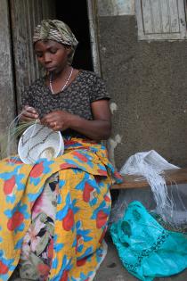Materialerne bilver genbrugt! - Kvinde i Kisoro syer her en kurv af bananpalme og strimler fra en plastiksæk. Foto Lisbeth Kristine Olesen